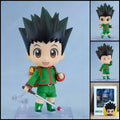 Gon Freecss HUNTER X HUNTER chibi action figure with spiky black hair, green outfit, fishing rod, backpack, interchangeable parts, and clear display base.