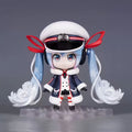Snow Miku VOCALOID chibi action figure with twin-tail hairstyle, white blue red and navy winter outfit, snow-inspired details, and clear display base.